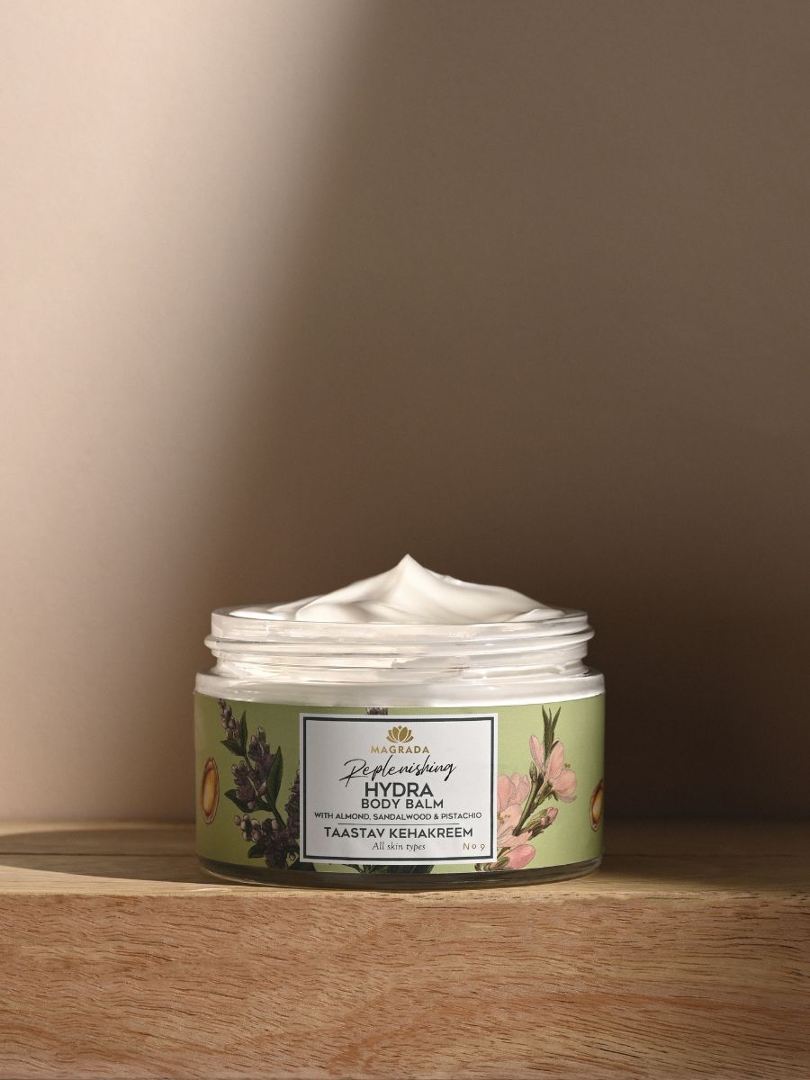 Magrada moisturizing balm Hydra Body Balm in a green jar with floral design on wooden surface
