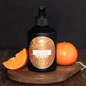 HOIA organic hair care mandarin shampoo bottle with fresh mandarin fruit on wooden board
