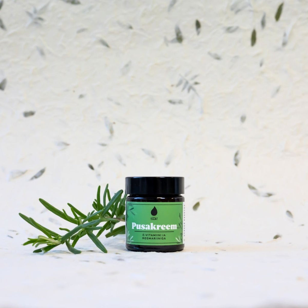 Tilk vitamin E hair detangling cream in a small green jar with natural herb on a white background